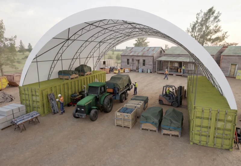 Farm equipment and supplies stored beneath an arched shelter.